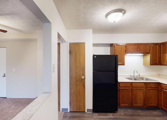 Wooden cabinets and black appliances at Quail Meadow Apartments, Cincinnati, OH