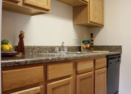 a kitchen with wooden cabinets and granite counter top and a sink  at Hunter's Creek Apartments, Cincinnati, 45242
