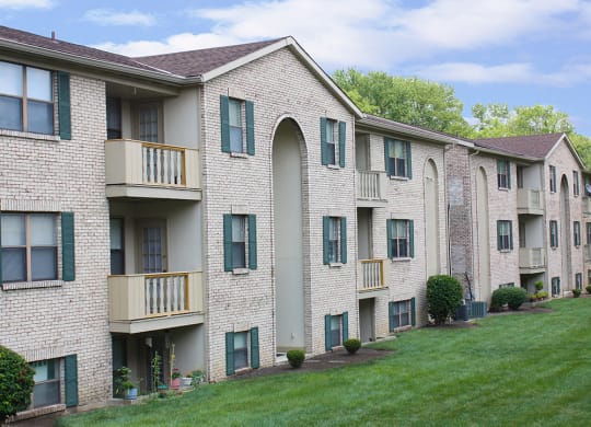 an exterior view of an apartment building with a green lawn  at Four Worlds Apartments, Cincinnati, Ohio