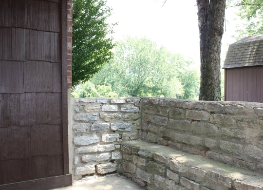 a stone wall with a bench next to a tree  at Four Worlds Apartments, Cincinnati, 45231