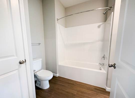 A white toilet is in a small white bathroom.