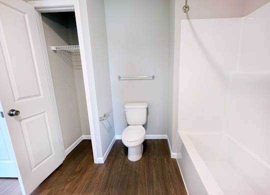A white toilet in a small bathroom with a white door.