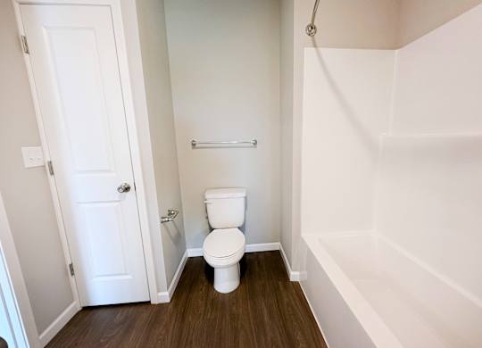 A white toilet in a small bathroom with a white door.