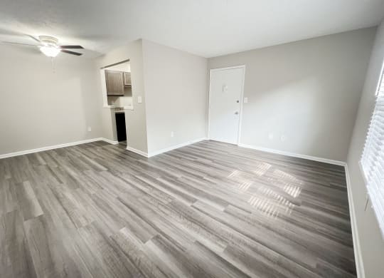 an empty living room with wood flooring in an apartment at Revere Village Apartments, Centerville, OH, 45458