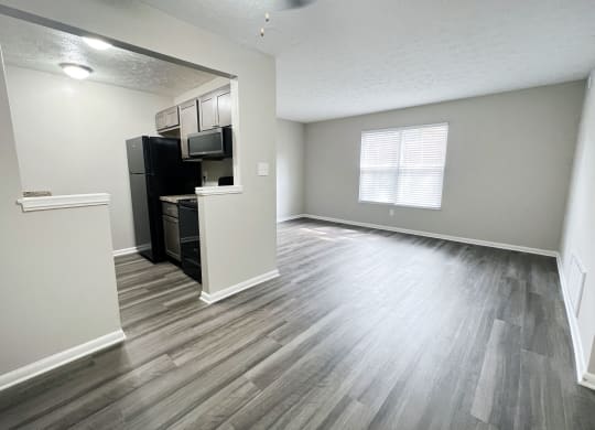 an empty living room and kitchen with hardwood flooring at Revere Village Apartments, Centerville, Ohio