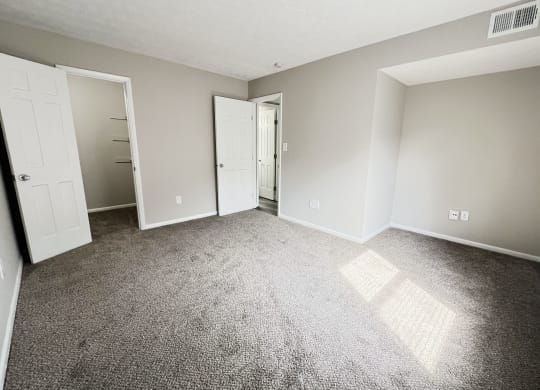 an empty living room with carpet and white doors at Revere Village Apartments, Centerville, 45458