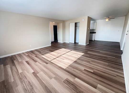 A room with wooden flooring and white walls.