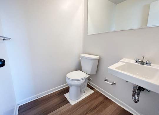 A white toilet sits next to a sink in a bathroom.