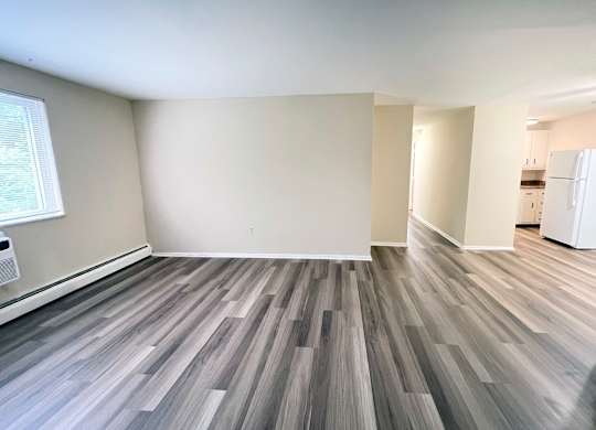 A room with wooden flooring and white walls.