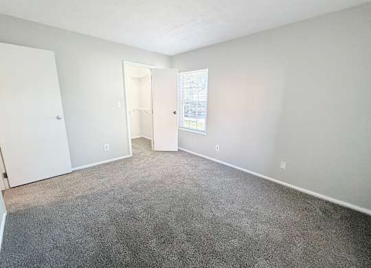 A room with a carpeted floor and white walls.