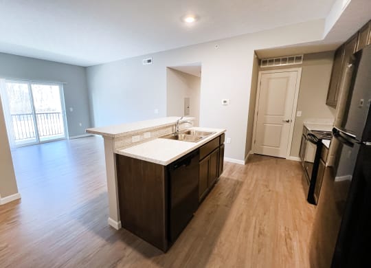 an empty kitchen and living room with wood flooring and a large window  at Brookfield Village Apartments, Ohio