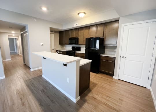 an open kitchen and living room with a white island and black appliances
