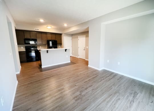 an empty living room and kitchen with wood flooring  at Brookfield Village Apartments, Grove City