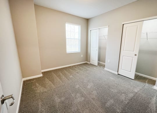 an empty bedroom with a closet and a door to the bathroom  at Brookfield Village Apartments, Grove City