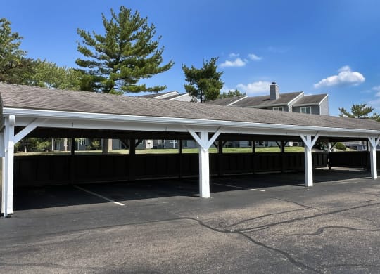 a covered parking lot with a building in the background at Deercross Apartments, Cincinnati