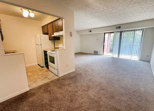 an empty kitchen and living room with a door to a balcony at Four Worlds Apartments, Cincinnati