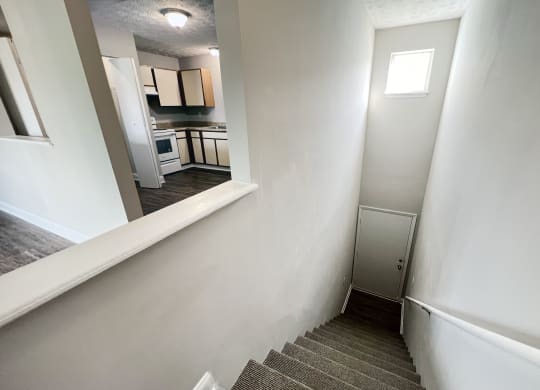 a stairwell in a home with white walls and a kitchen at 450 on Keeneland Apartments, Richmond, 40475