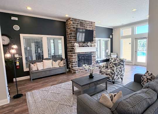 A living room with a grey couch, a fireplace, and a television.