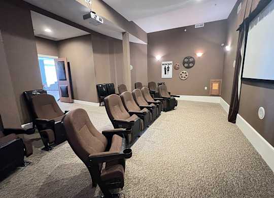 a large room with a row of chairs and a projector screen at The Residences at Liberty Crossing, Columbus, Ohio