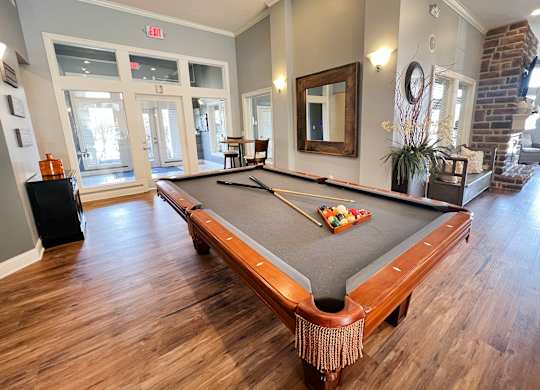 a billiards table in a living room with wood floors at The Residences at Liberty Crossing, Columbus