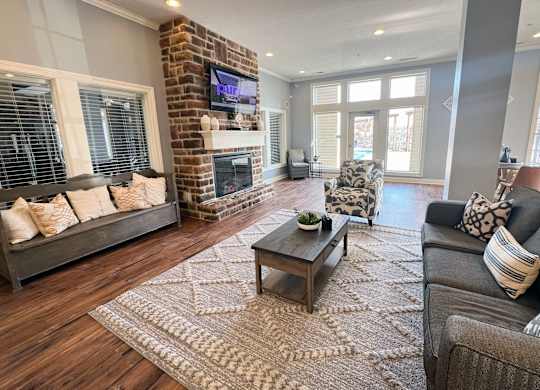 a living room with a brick fireplace and couches at The Residences at Liberty Crossing, Columbus, OH, 43235