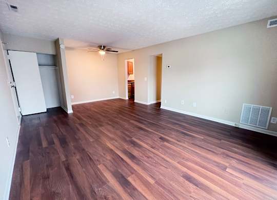 A room with wooden flooring and a ceiling fan.