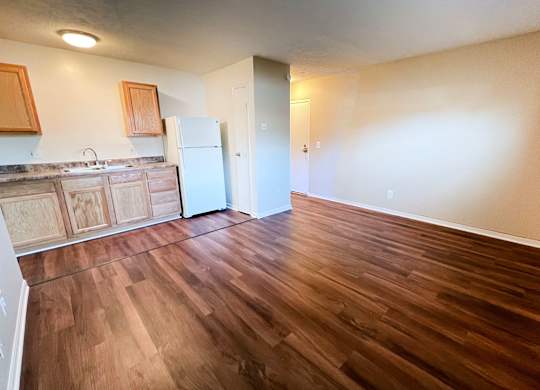 A kitchen with wooden floors and a white refrigerator at Crown Crossing Apartments, Amelia, Ohio, 45102