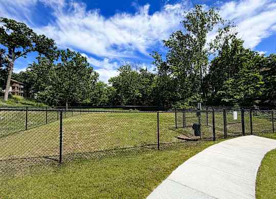 A park with a fence and a walkway.