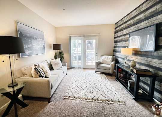 a living room with a couch and a chair and a rug at The Residences at Liberty Crossing, Columbus