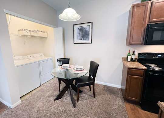 A small dining area with a glass table and a black chair.