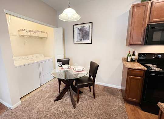 a kitchen and dining room with a small table and chairs at The Residences at Liberty Crossing, Columbus, 43235