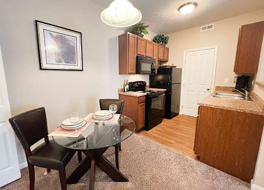 an open kitchen and dining area with a glass table at The Residences at Liberty Crossing, Columbus, 43235