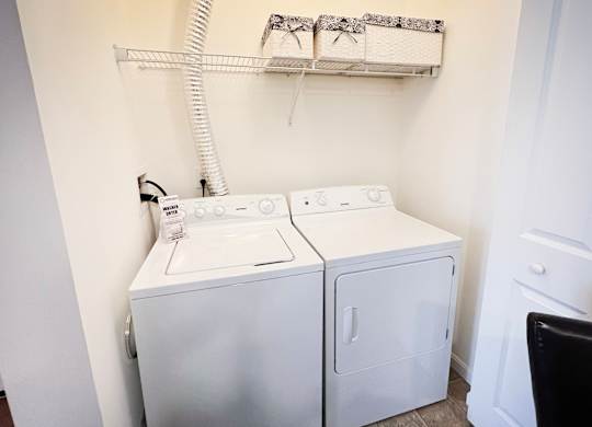 a white washer and dryer in a white laundry room