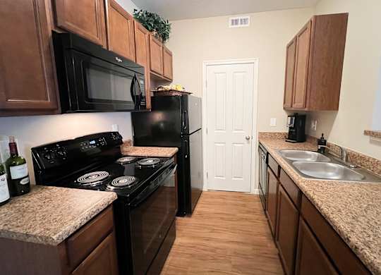 a kitchen with black appliances and granite counter tops at The Residences at Liberty Crossing, Columbus, Ohio