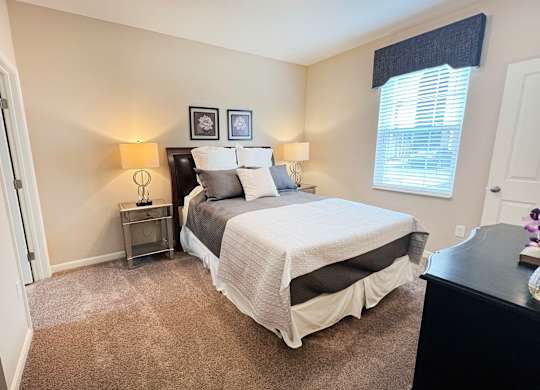 a bedroom with a bed and a dresser and a window at The Residences at Liberty Crossing, Columbus, Ohio