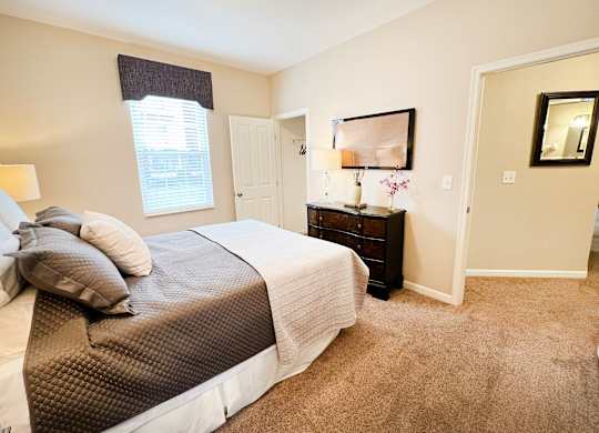 a bedroom with a bed and a door to a bathroom at The Residences at Liberty Crossing, Columbus, OH, 43235
