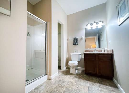 A bathroom with a toilet, sink, and mirror.