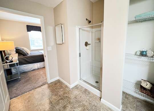 a bathroom with a shower and a bedroom with a bed at The Residences at Liberty Crossing, Columbus