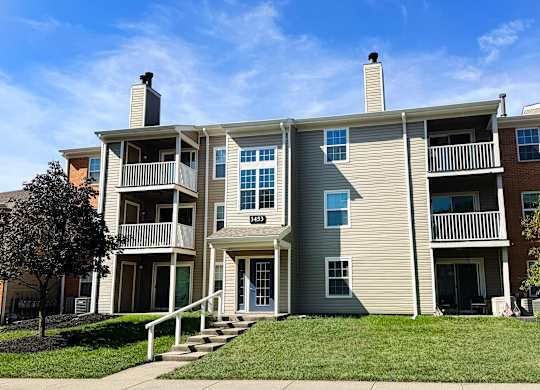 A two-story apartment building with a balcony on the second floor.