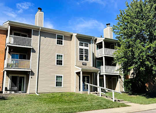 Apartment building with a tree in front.