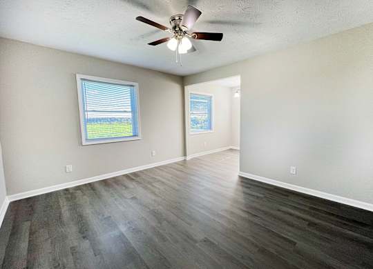 A room with a ceiling fan and a window.