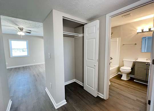 A bathroom with a toilet, sink, and a window.