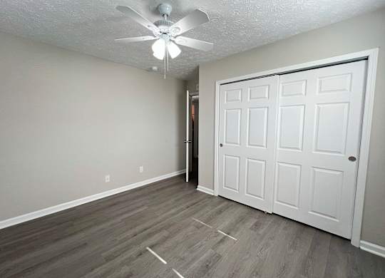 A room with a white ceiling fan and a white door.