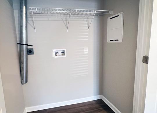 A white closet with a shelf and a white door.