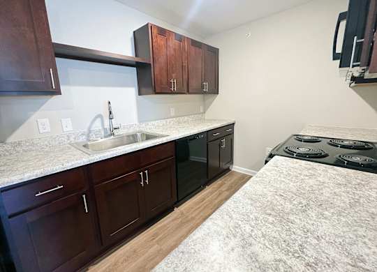 A kitchen with dark brown cabinets and a white marble countertop.