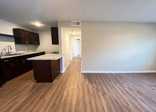 A kitchen with dark wood cabinets and a white countertop.