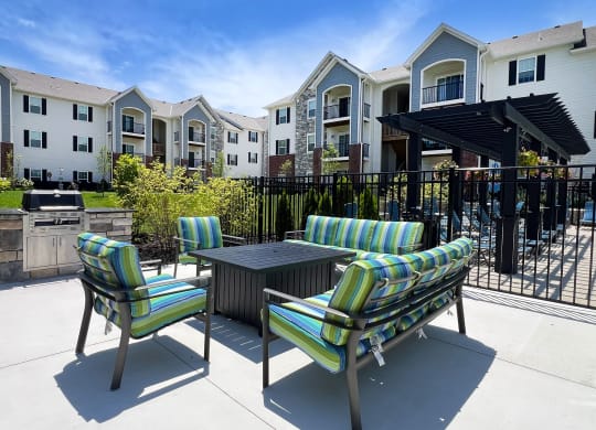 a patio with chairs and a table in front of an apartment building at Parkway Trails, Florence, KY