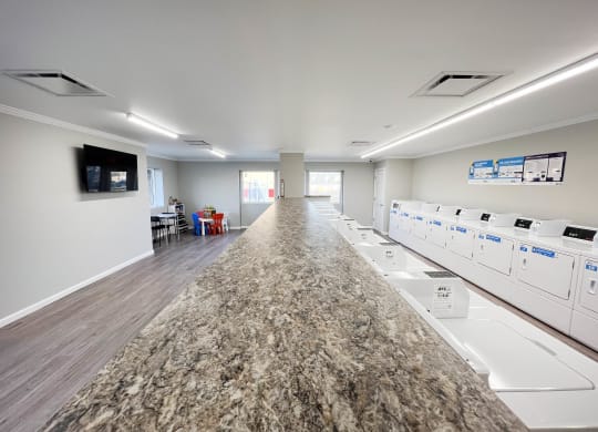 a long counter in a room with washers and dryers  at Forest Park Apartments, Forest Park