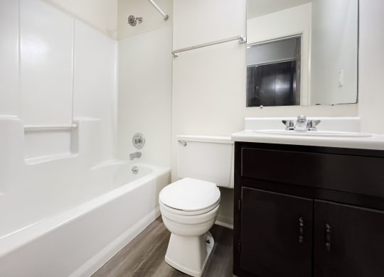 an empty bathroom with a toilet and a bath tub at Four Worlds Apartments, Cincinnati
