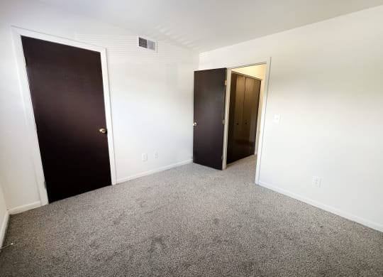 an empty room with two doors and a door to a closet at Four Worlds Apartments, Ohio
